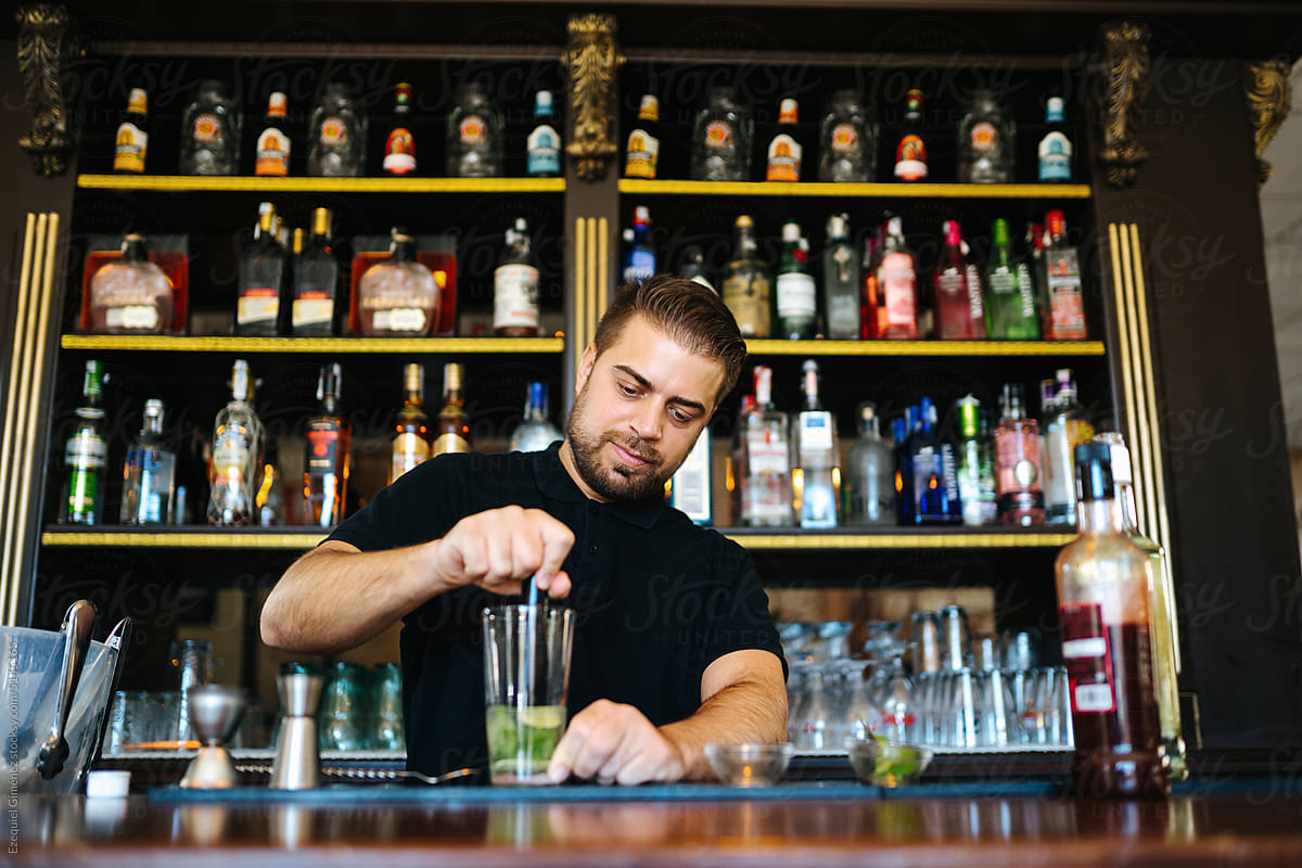 Barkeeper squeezing lime juice for cocktail