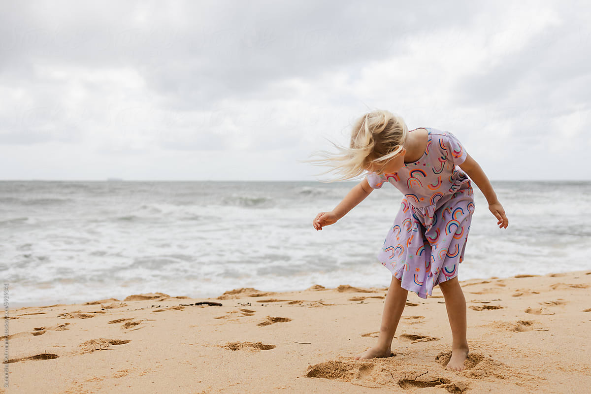 Little girl enjoying a windy beach