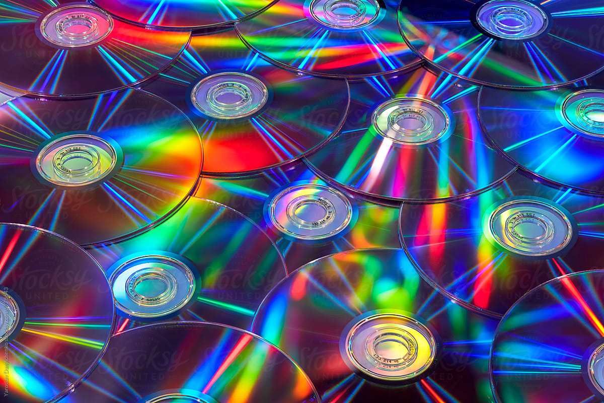 Old compact CD discs with rainbow light on surface