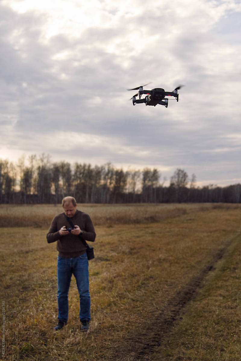 Man piloting drone over field
