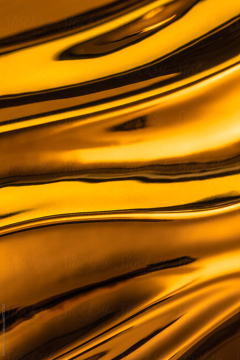 Abstraction in the form of golden metallic fabric with shiny curves
