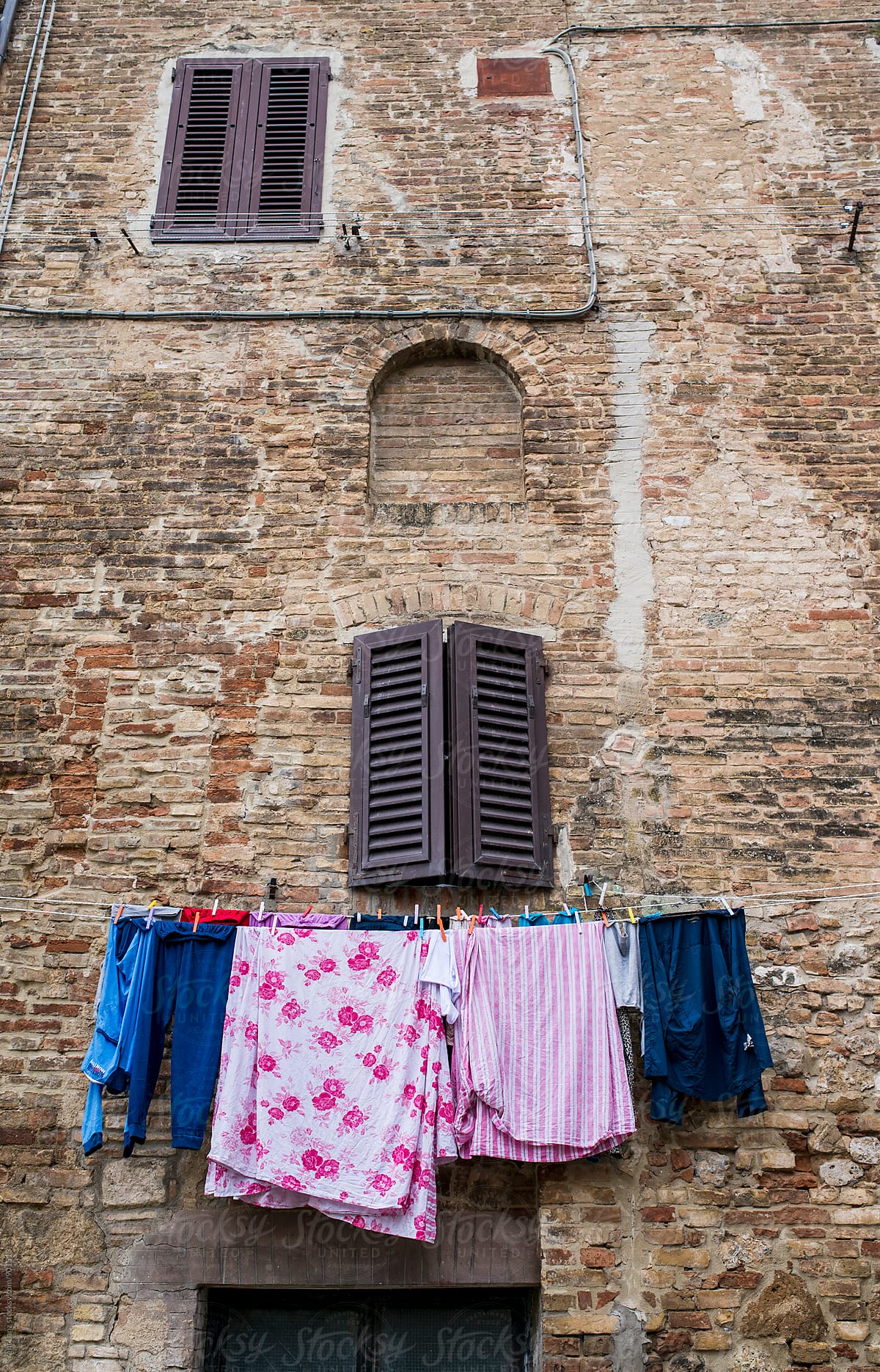 View on clothes hanging on rope under shuttered window