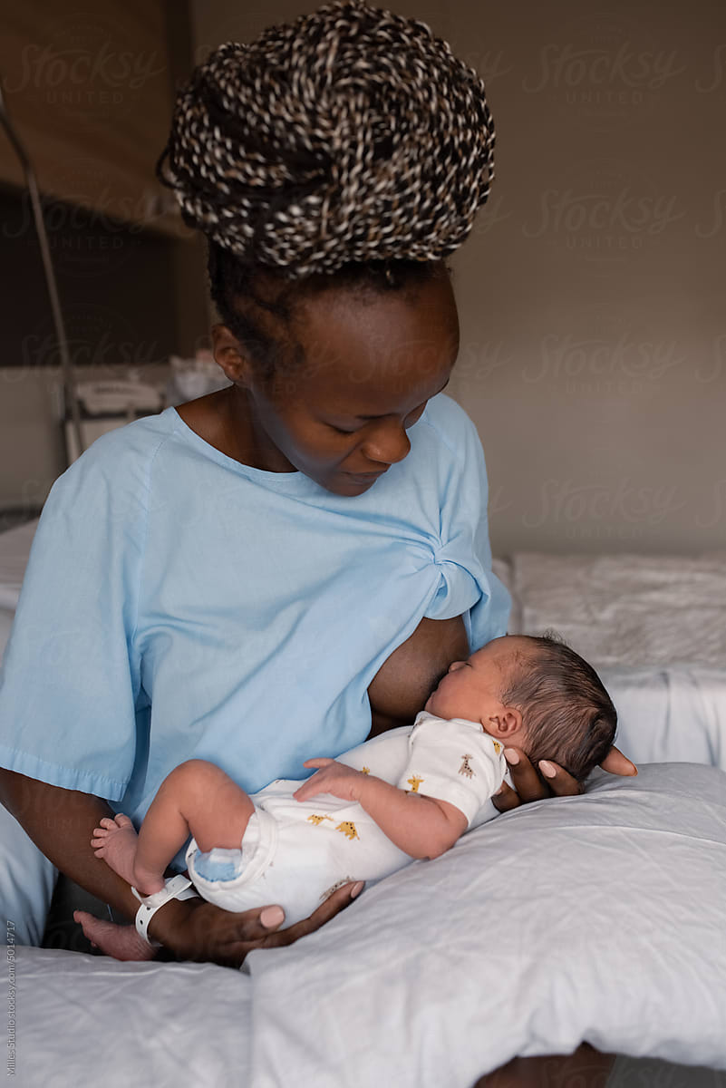 African Mother Breastfeeding Baby In Hospital Room by Stocksy