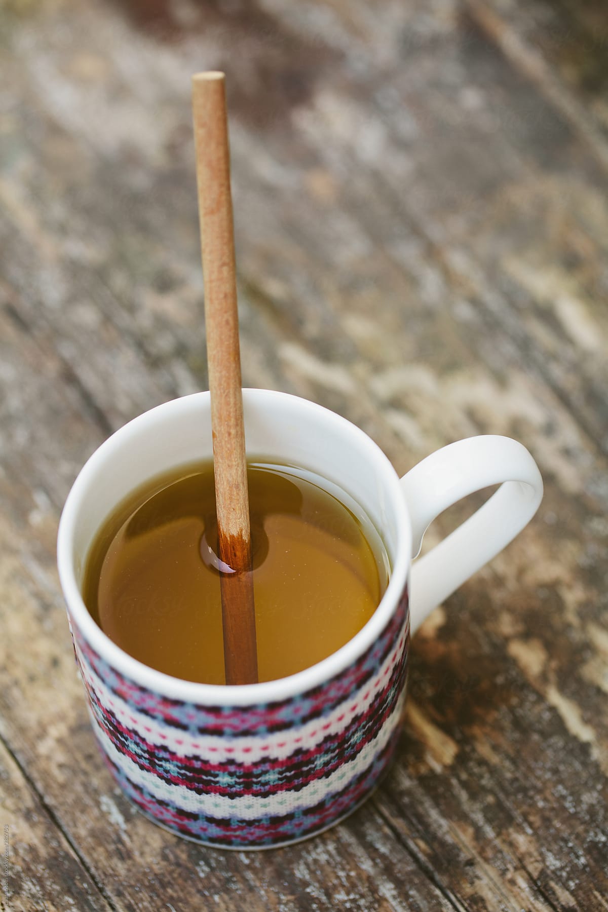 Overhead shot of tea in fine china mug with wooden poon in it
