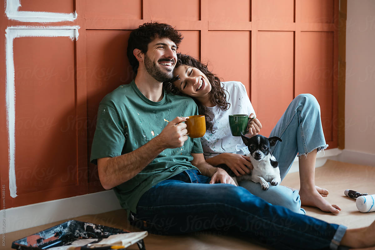 Positive couple sitting in messy renovated room