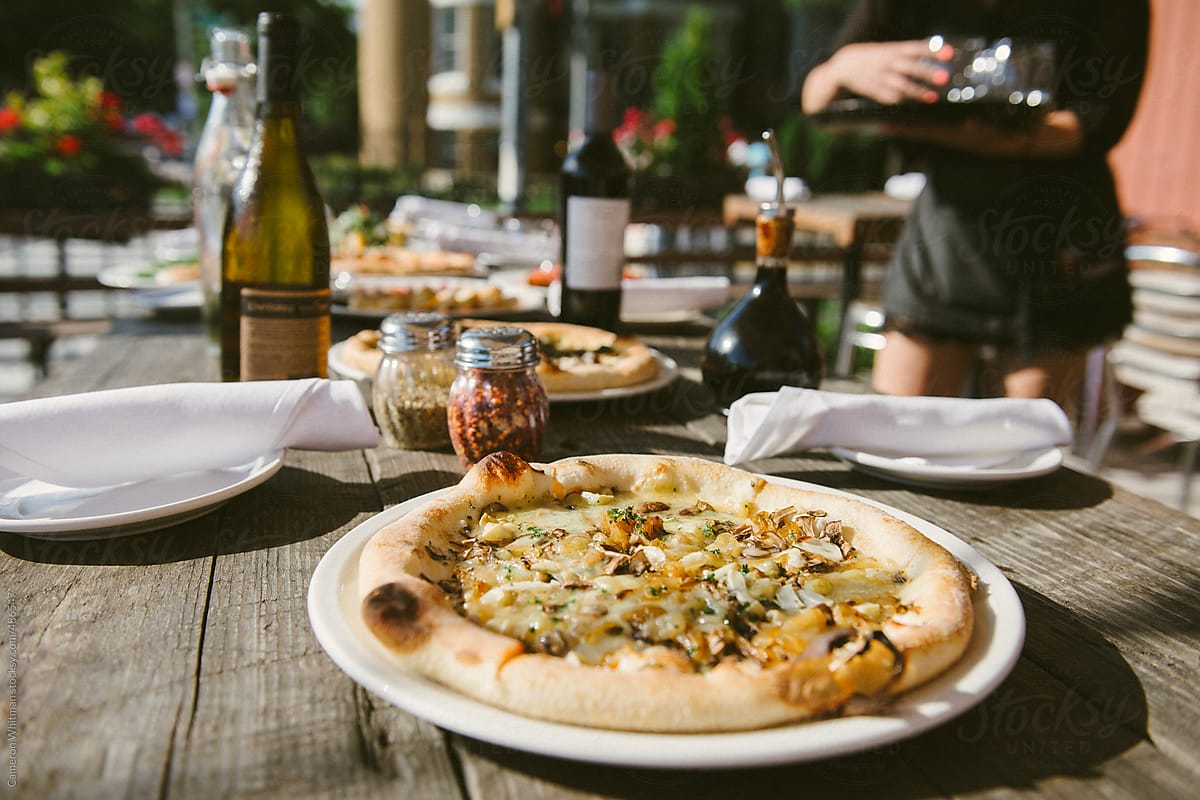 Outdoor restaurant table with pizzas