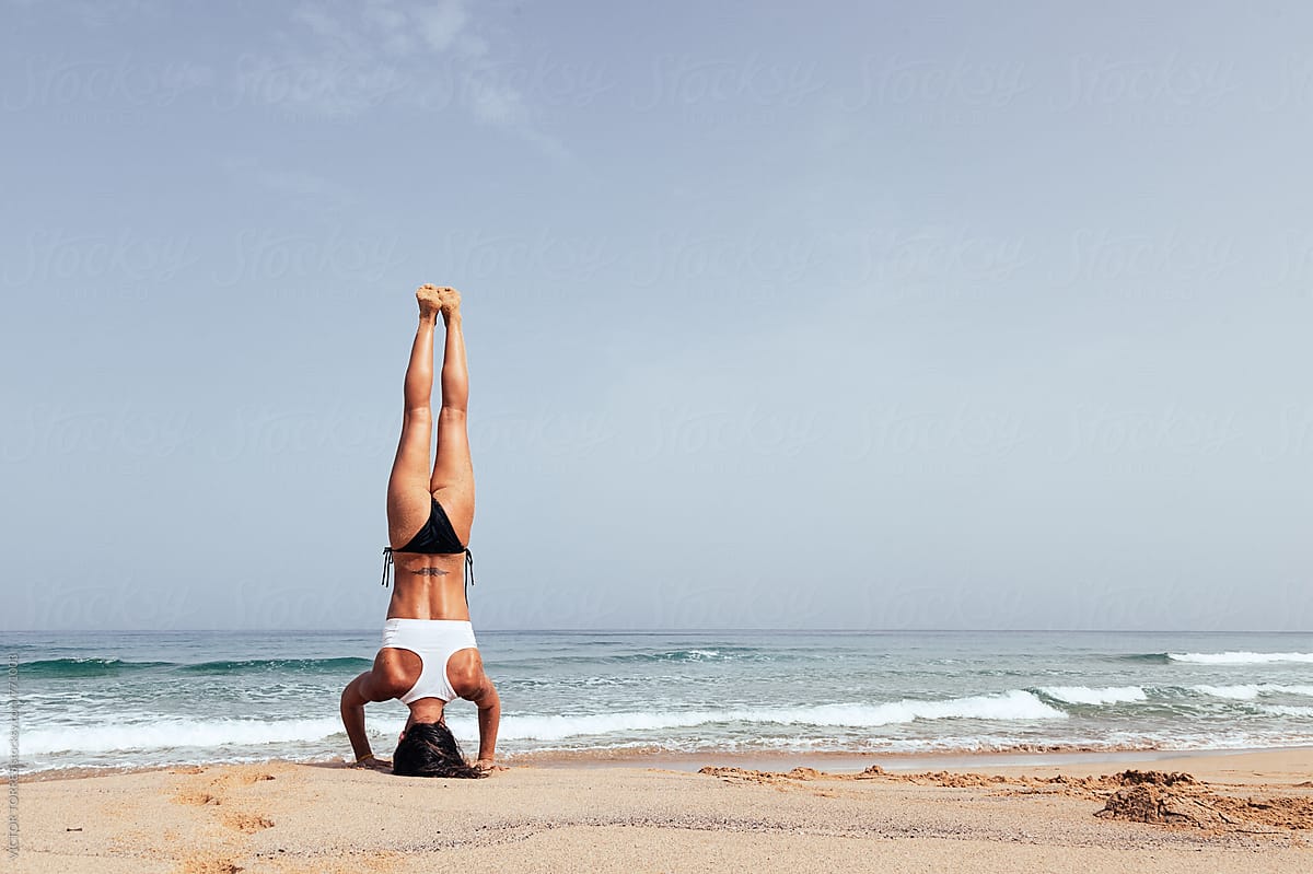 Woman Doing Yoga Exercises At The Beach By Stocksy Contributor Victor Torres Stocksy