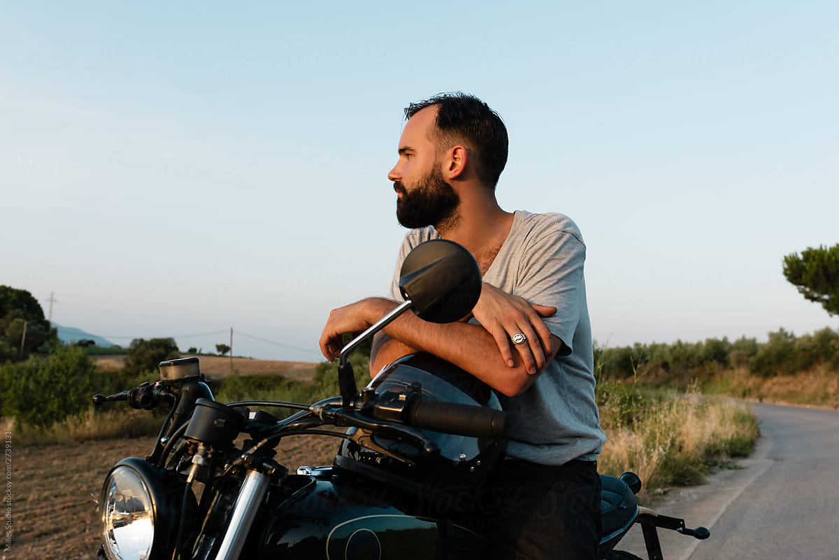 Bearded man on motorbike looking away in nature