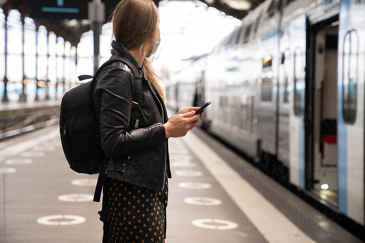 Anonymous Woman Holding Smartphone At Railway Station