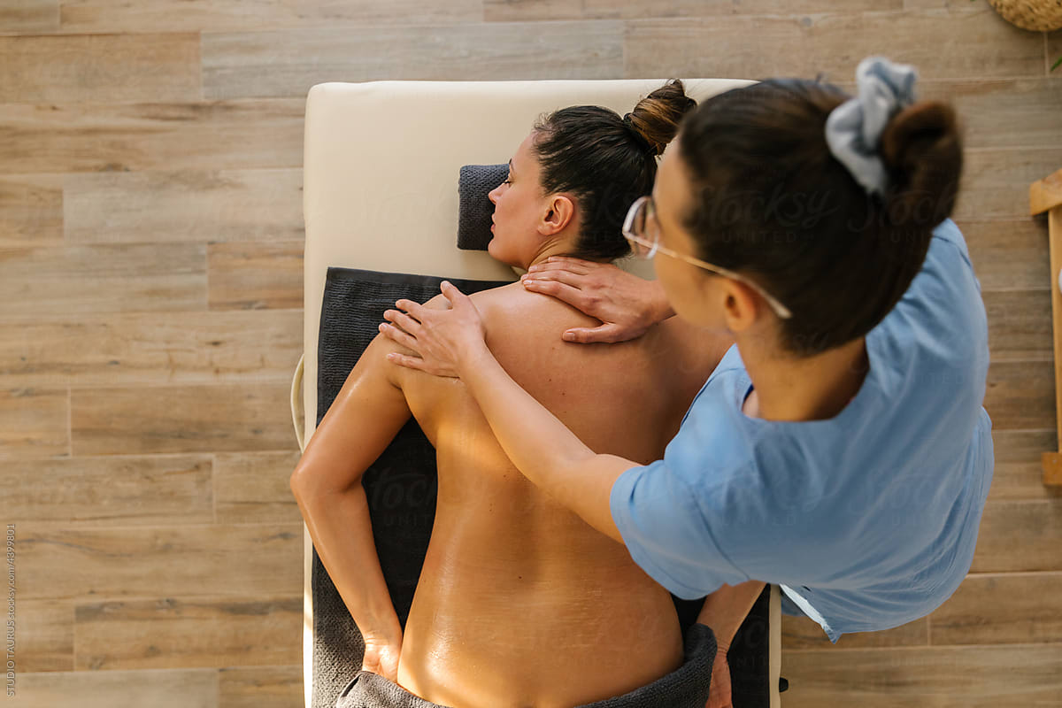 Caucasian woman enjoying full body massage at spa