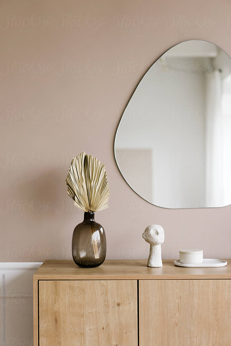 Mirror and wooden cabinet with decorative elements in room