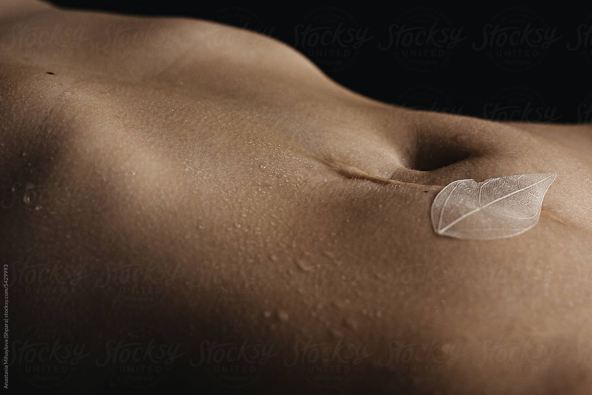 Close Up photo of woman\'s scar on belly and white leaf
