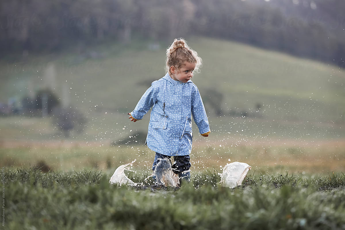 Little girl splashing in puddle