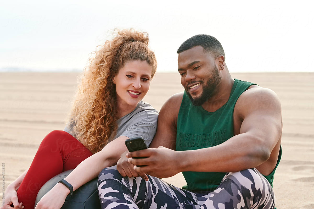 Friends Taking Selfies After A Beach Workout By Stocksy Contributor Ivan Gener Stocksy 0591