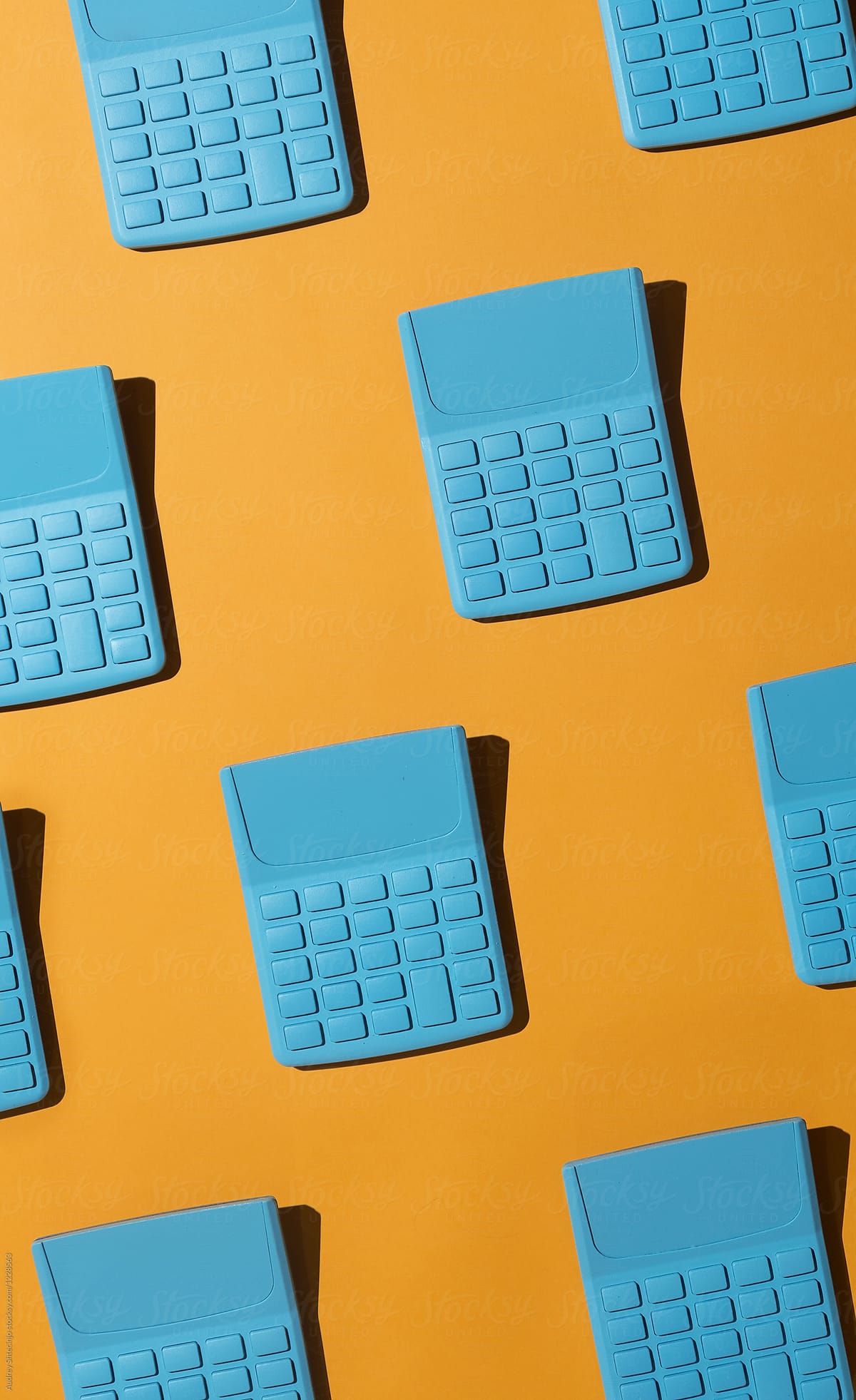 Blue pocket calculators on orange background.