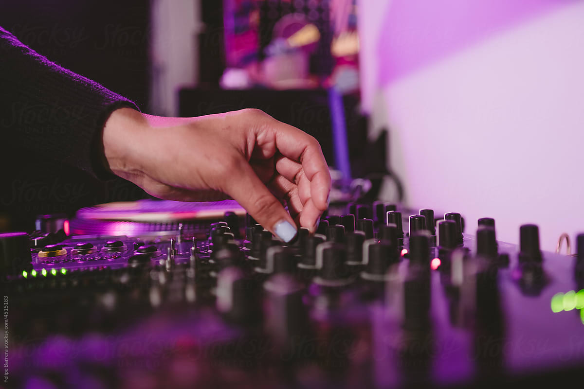 Hands of DJ operating a sound mixer