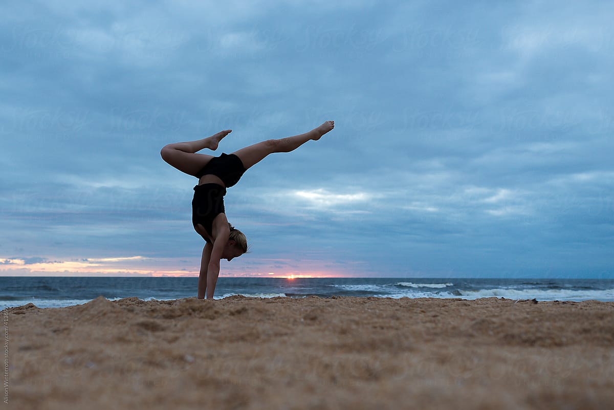 Woman Doing Handstand On The Beach at Sunrise