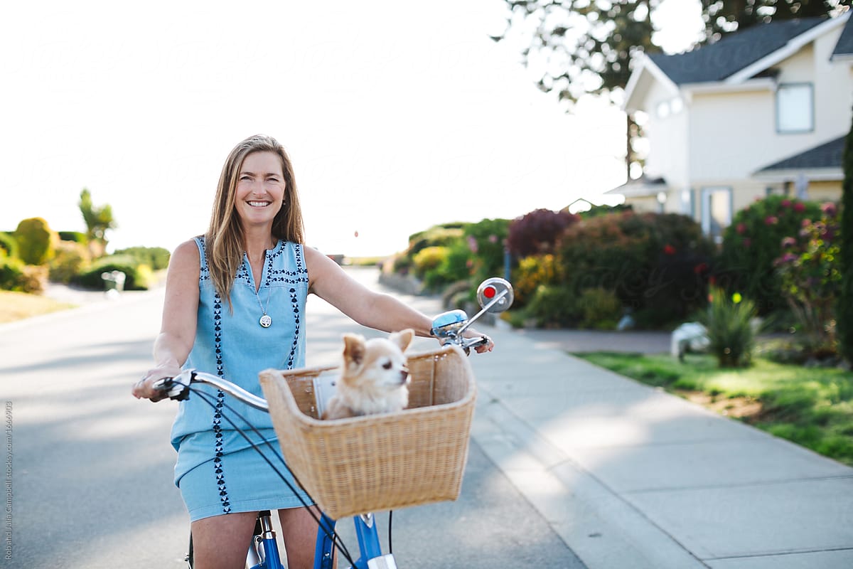 Healthy, active woman enjoying life riding cruiser bike with pet