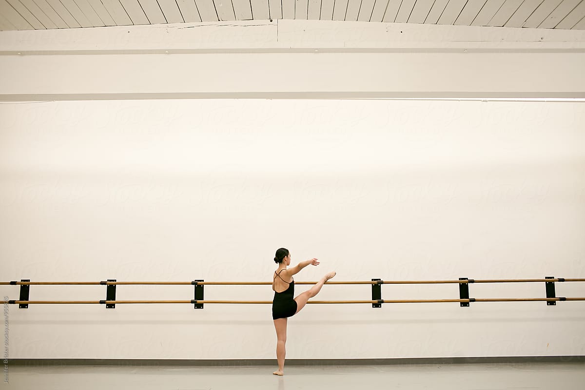 Young dancer stretches in studio