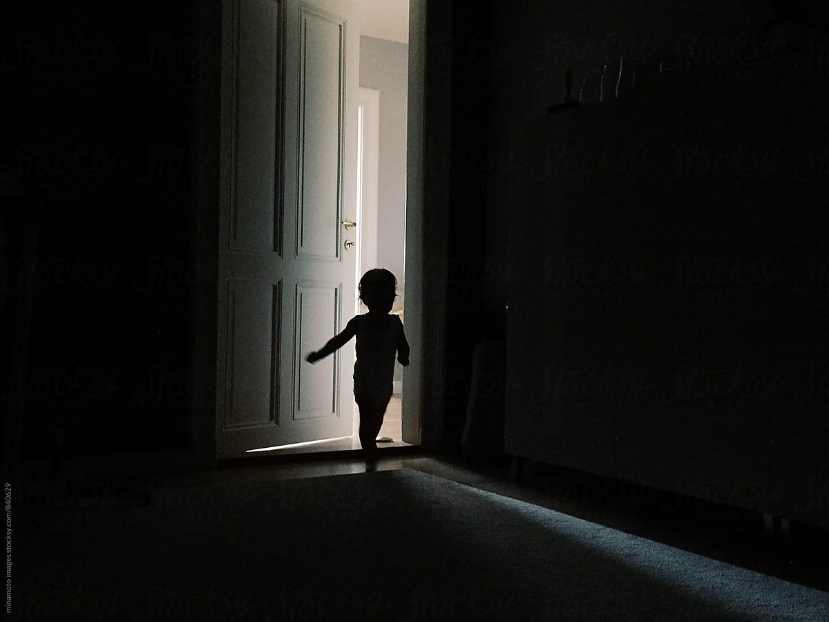 Little toddler running into dark room