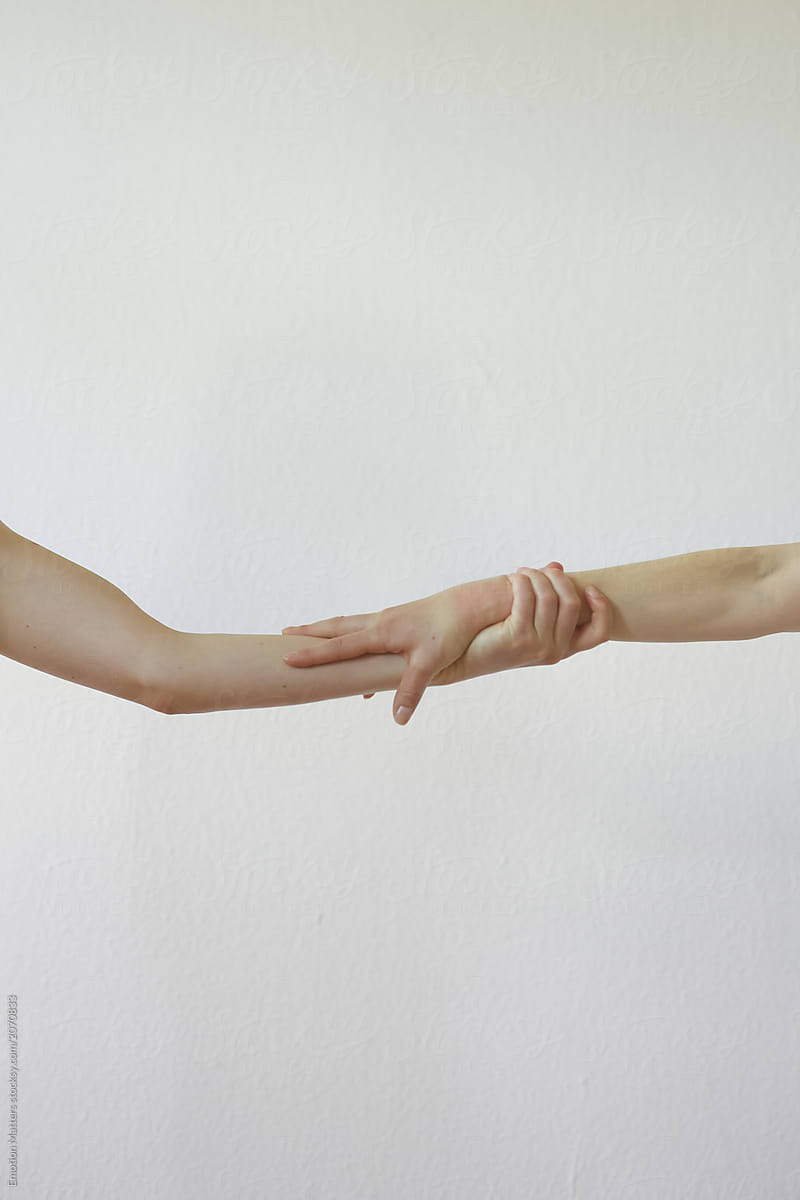 Two hands from different people holding together.