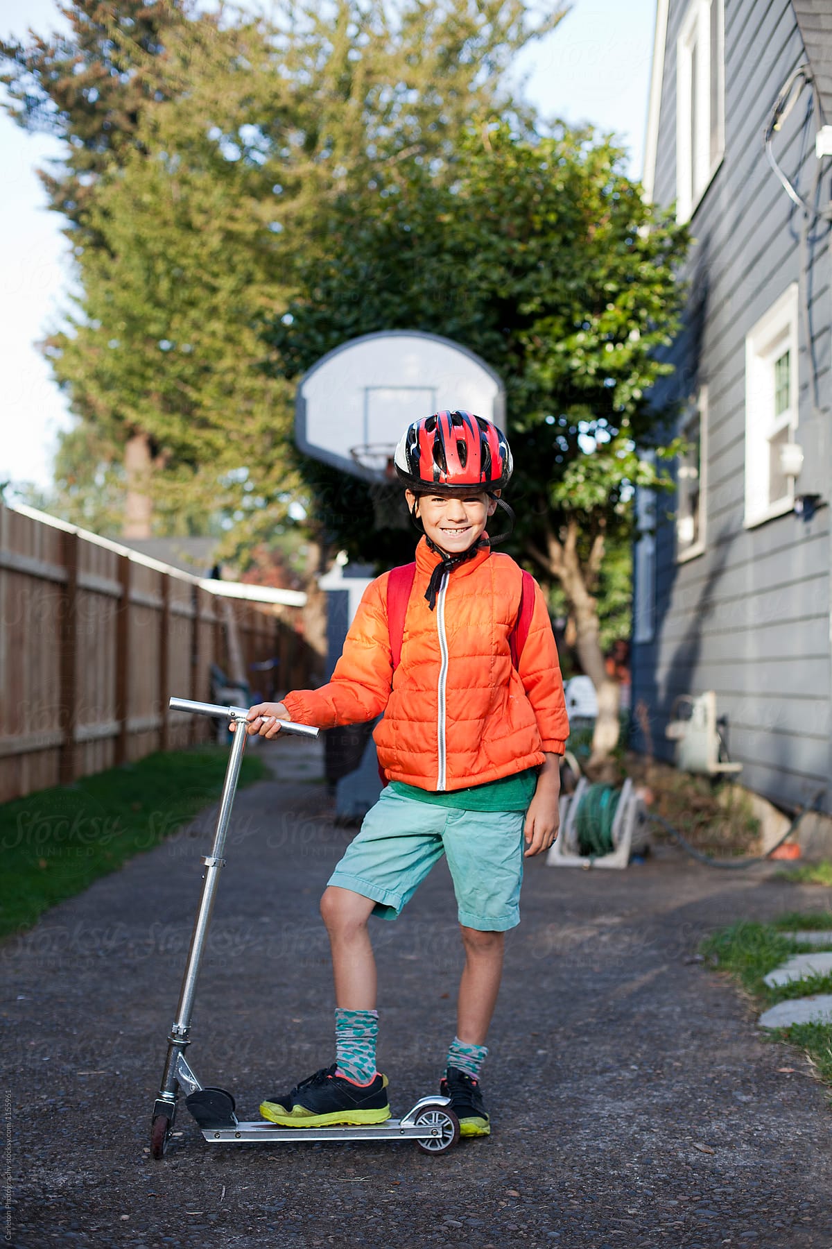 Seven year old boy is ready to go to school on his scooter