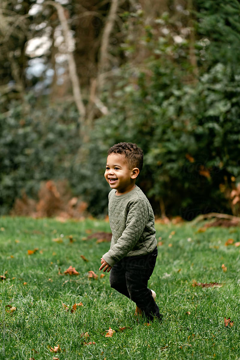 Smiling Little Boy Walking in Grass