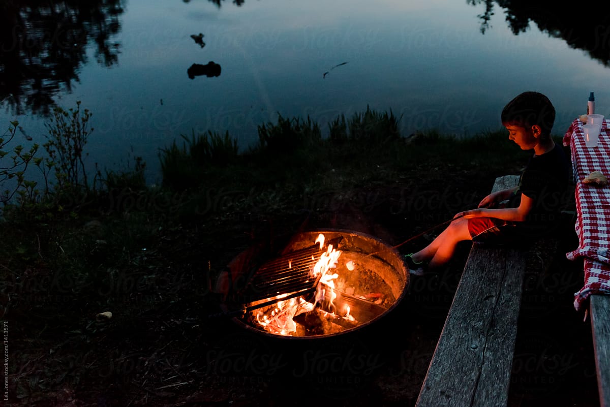 kid grilling marshmallows on campfire