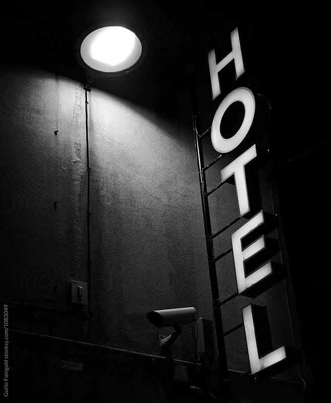 Hotel signboard on wall with street lamp at night