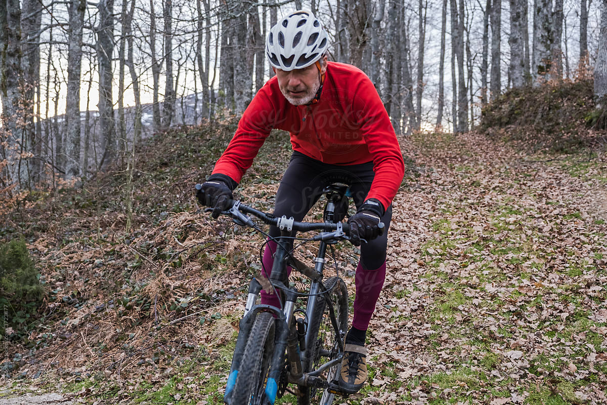 A senior athlete concentrating while biking downhill