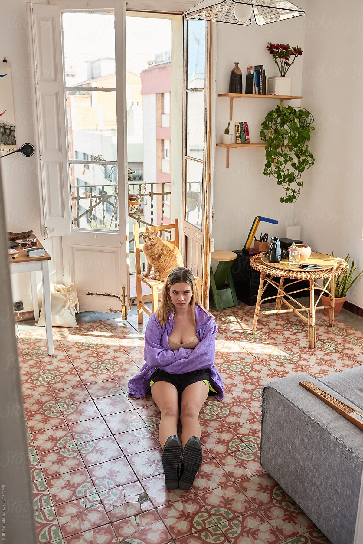 Girl in violet jacket and black boots sitting on floor