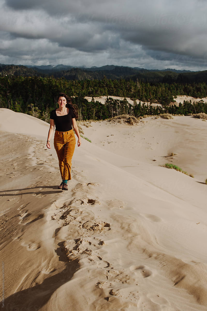 Woman walking on sand dune