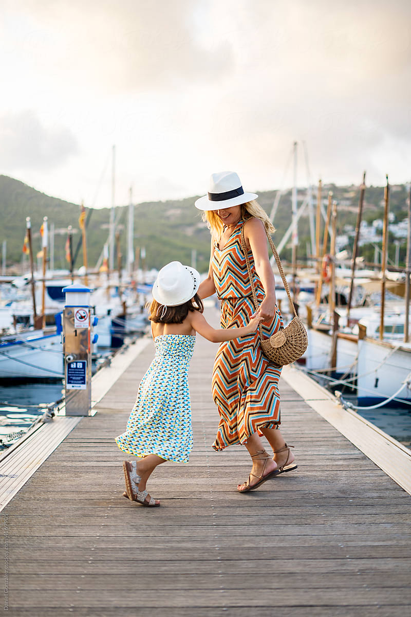 Mother and daughter dancing on pier
