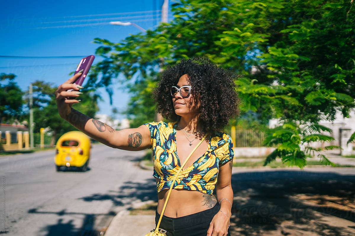 A girl takes a photo on the street with her cell phone