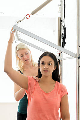 A 20-year-old trainer practices Pilates on an elevator chair with the help  of a gymnastics rubber band for her shoulder muscles Stock Photo - Alamy