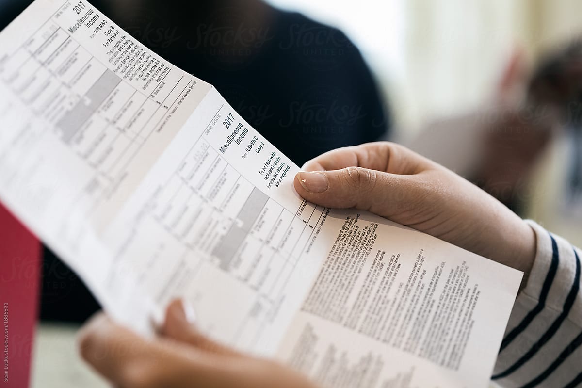 Taxes: Woman Reading W-2 Information On Paper