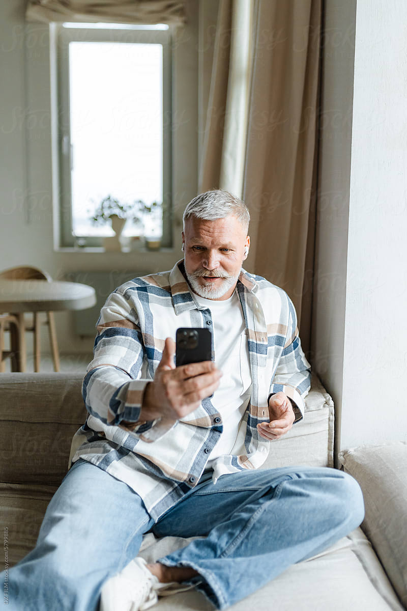 A man uses a mobile phone at home
