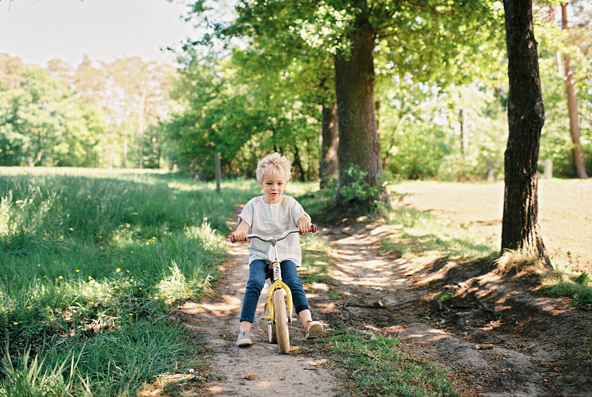 A boy with a yellow bike in the great outdoors