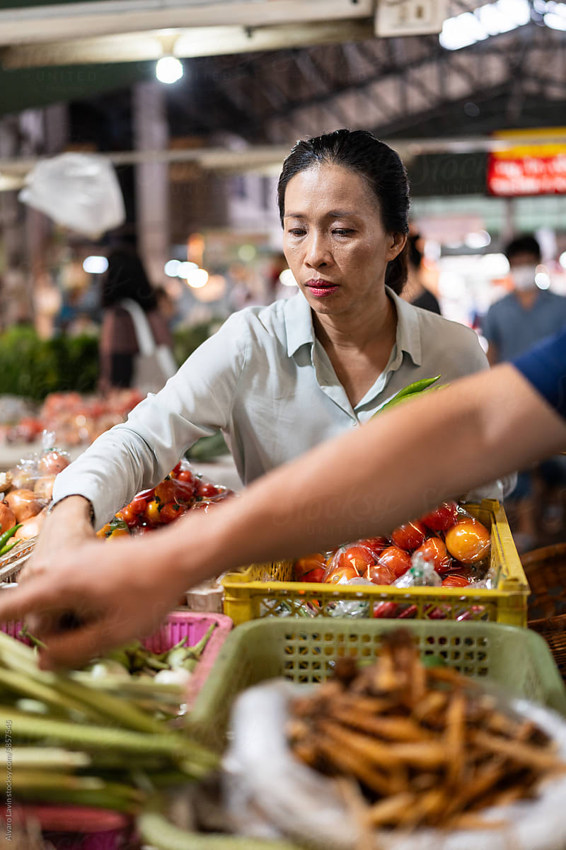 Woman buying at Thai food market.