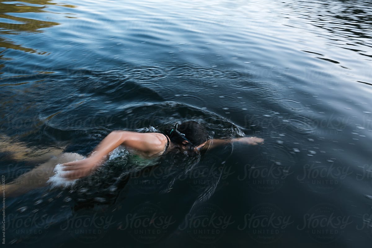 Action shot of woman swimming in fresh water lake