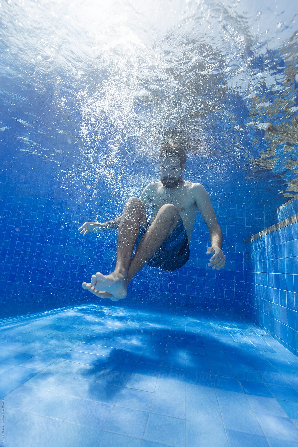Man underwater in the pool after a jump