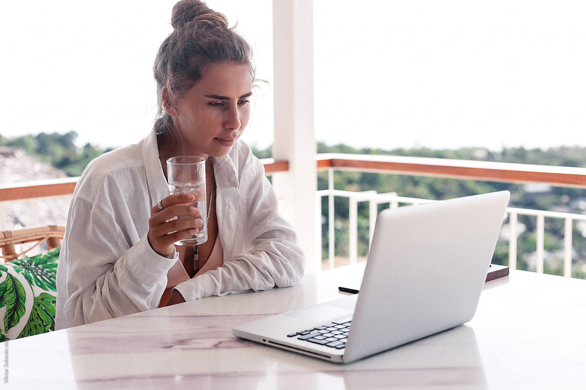 Young woman watching online streaming and drinking water.