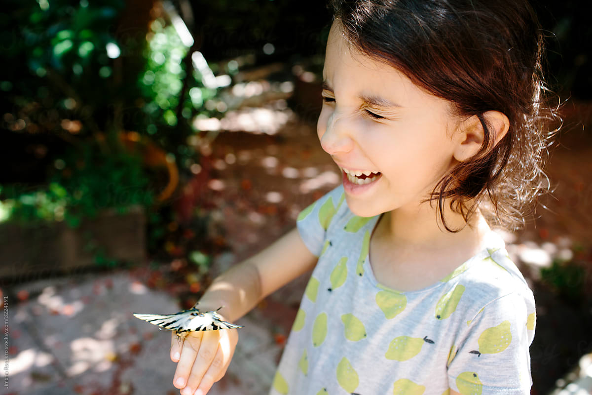 Kid laughing at butterfly tickling