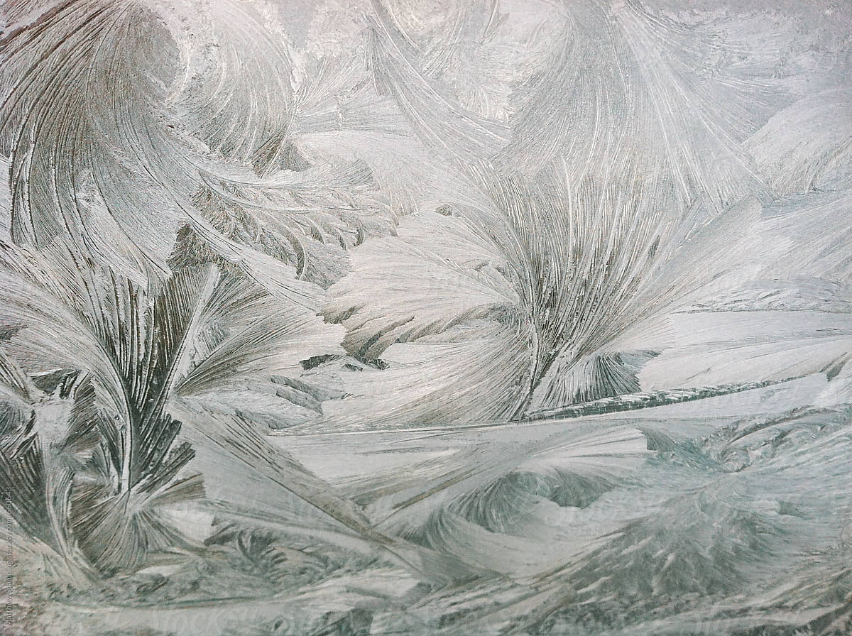 Ice and frost formation with feather pattern on car windshield