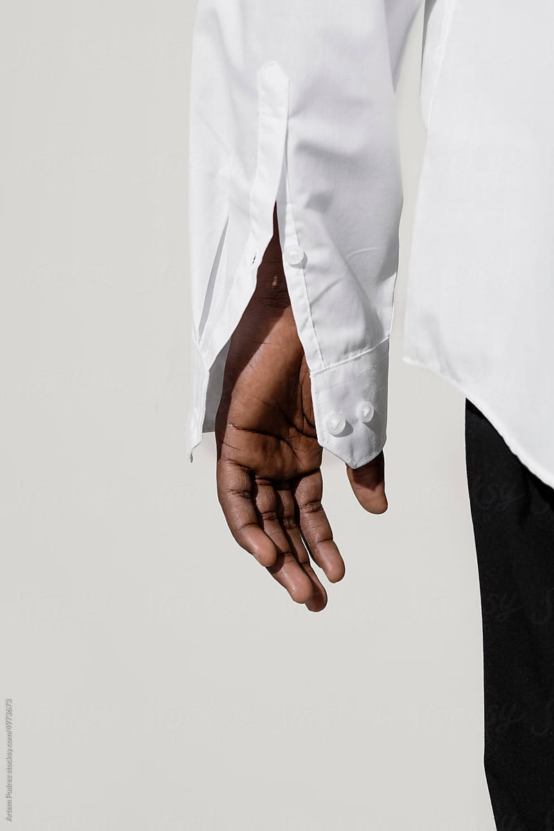 A hand in a shirt on a gray background
