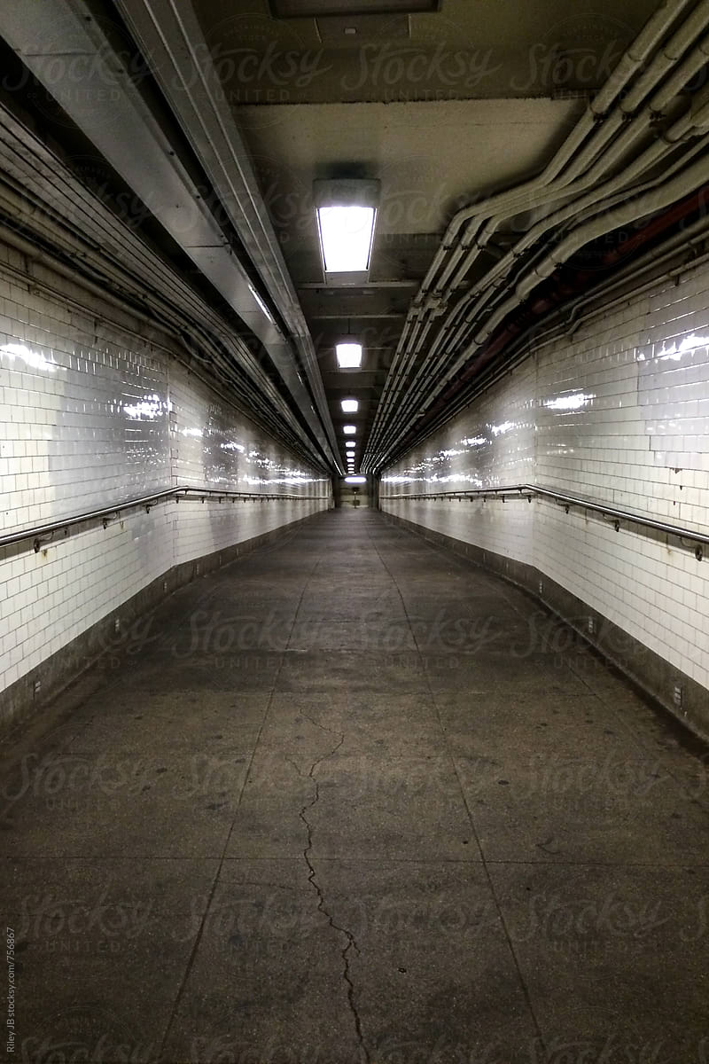 An empty, gritty walkway into a NYC subway station