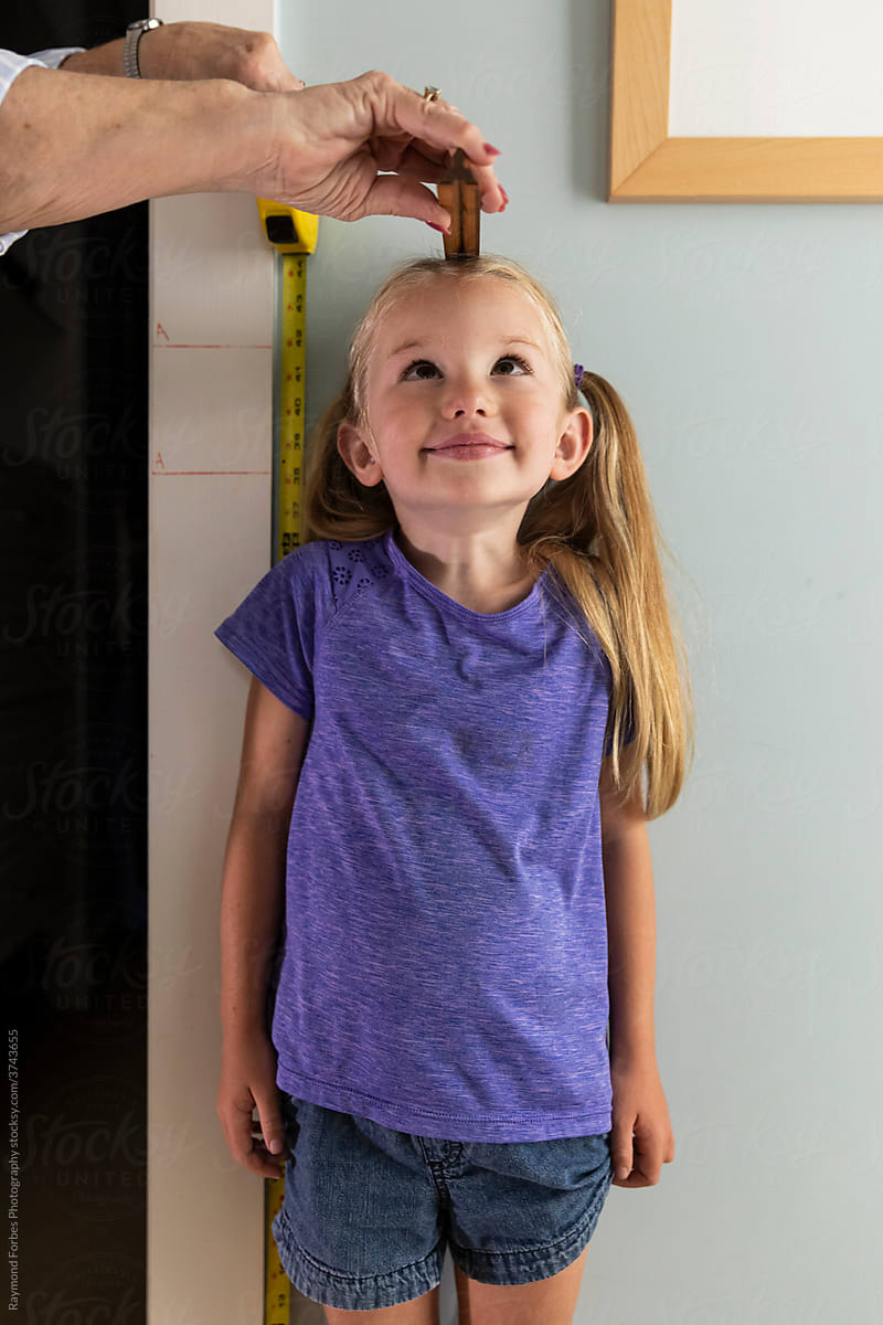 Young Girl with pigtails Measuring her height