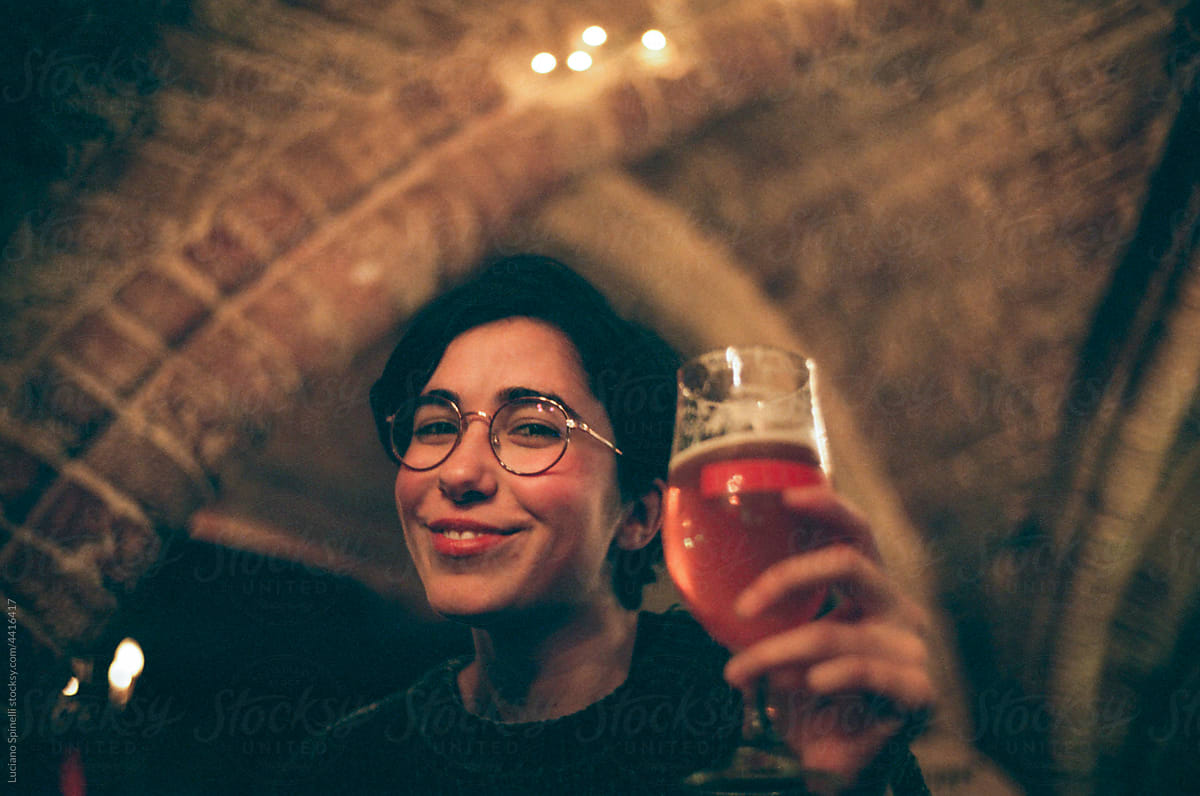 Young woman hold a glass of beer in a trappiste style Belgium bar