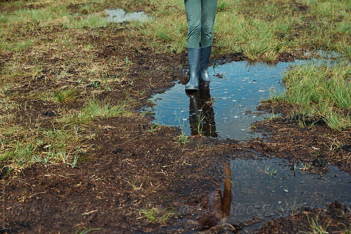 A kid going in muddle puddle in the nature
