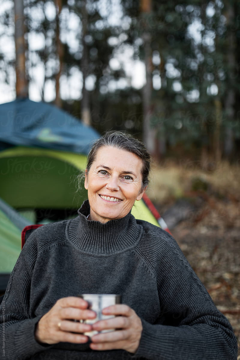 mature woman with a cup of coffee in nature